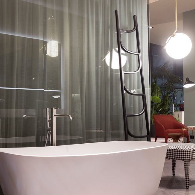 Salle de bain luxe — baignoire îlot blanche, robinetterie au sol, éclairage design