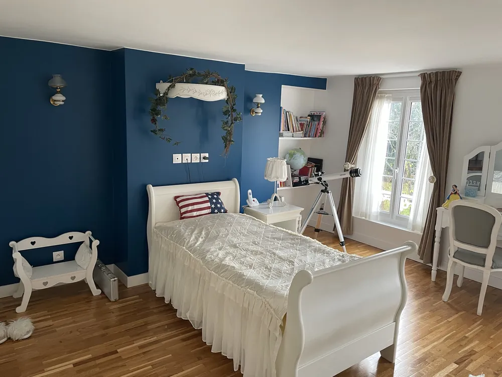 Chambre enfant rénovée Paris — mur bleu, parquet ancien restauré