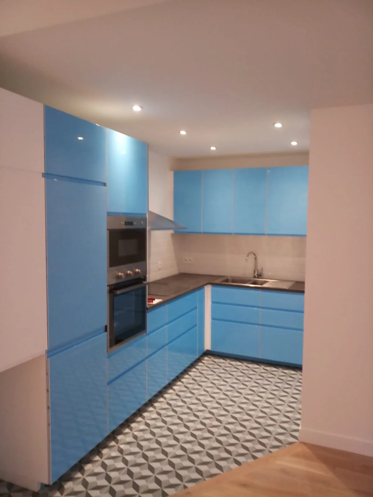 Cuisine équipée bleu ciel avec sol en carreaux de ciment après rénovation, Paris 14e