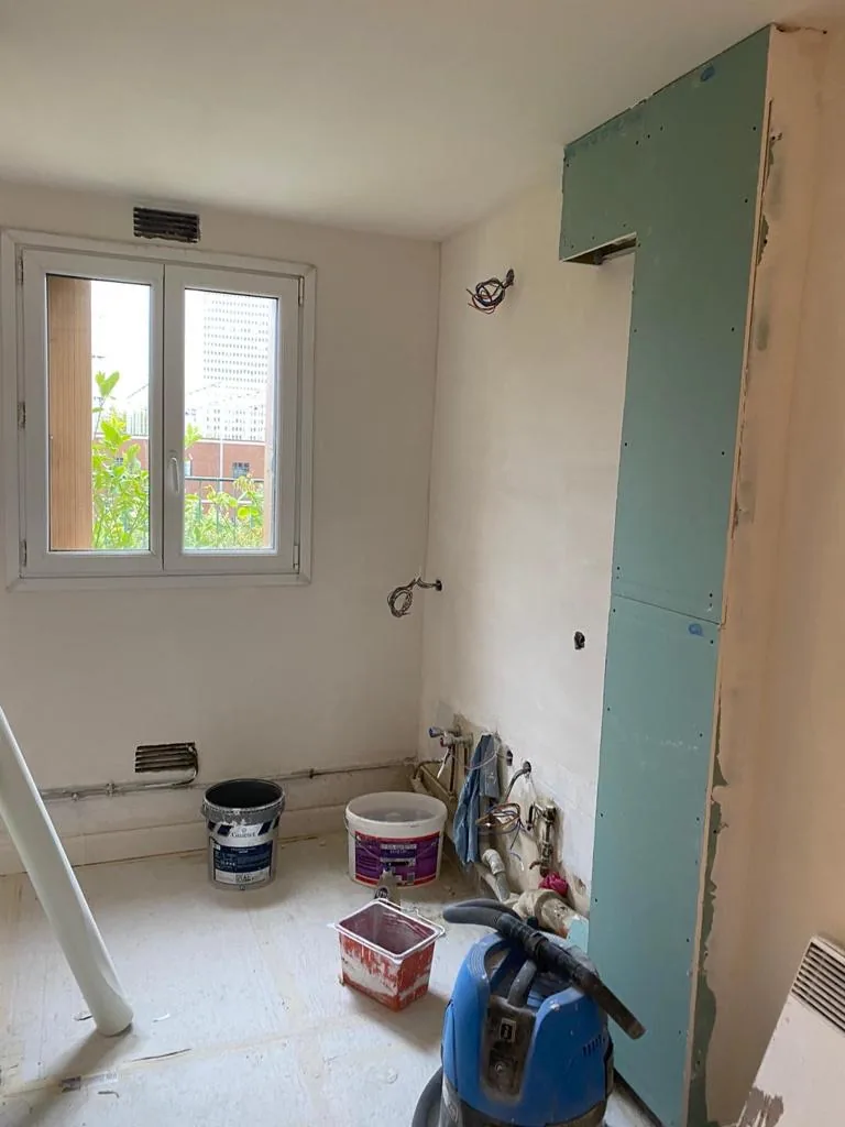 Pièce en cours de travaux avec cloison en plaques de plâtre et protections au sol, appartement Paris 14e