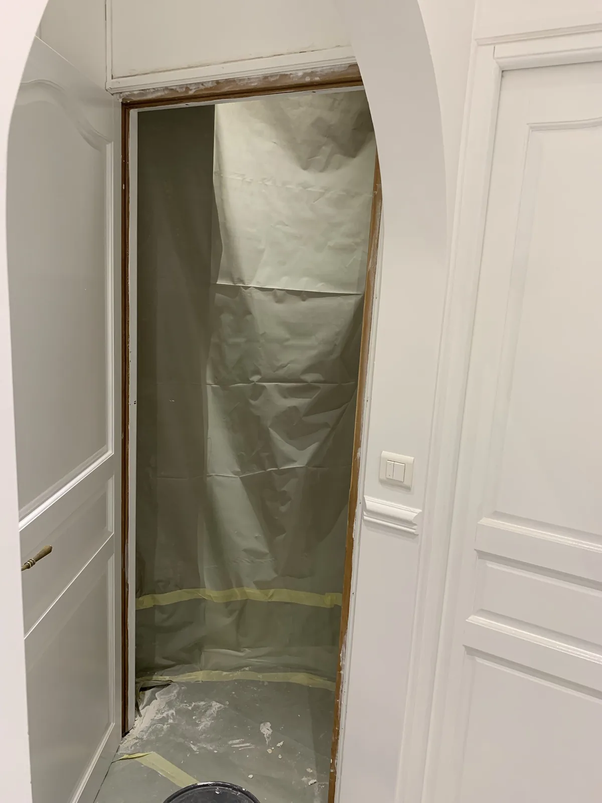 Porte et encadrement protégés par du papier de masquage avant la mise en peinture, appartement haussmannien Paris 16e